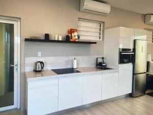 a white kitchen with a sink and a refrigerator at Holiday Haven - Jan Thiel in Jan Thiel