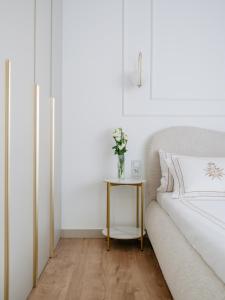 a bedroom with a bed and a table with a vase of flowers at Willa Ada Pokoje & Apartamenty in Karwia