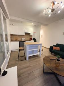 a living room with a table and a kitchen at À quelques pas de la gare - RER A in Sartrouville