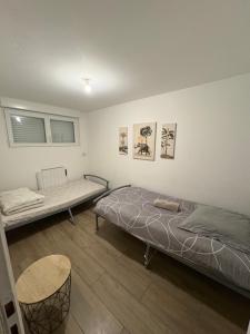a room with two beds and a table at À quelques pas de la gare - RER A in Sartrouville