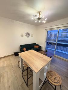 a living room with a table and a couch at À quelques pas de la gare - RER A in Sartrouville