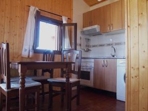 a kitchen with a table and chairs and a window at Fuente Del Arca in Cañamares