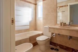 a bathroom with a toilet and a sink and a tub at Modern Sea & Golf View 2-Bedroom Apartment with Pool and Terrace in Calanova in Mijas