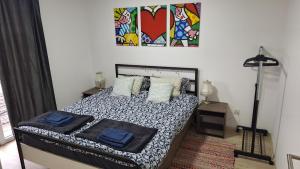 a bedroom with a bed and a painting on the wall at Play Apartments in Paraćin
