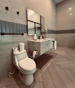 a bathroom with a toilet and a sink with a mirror at Paraiso Rainforest and Beach Hotel in Omoa +100 photos