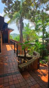 a patio with a tree and a stone wall at Rosies on Robin - Pool, Braai & Mountain Views in Rustenburg