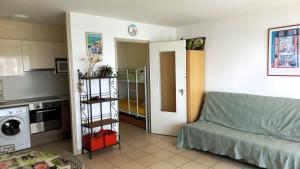 a living room with a couch and a kitchen at Studio Cabine Climatisé tout près de la plage in Le Grau-du-Roi