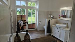 a bathroom with a tub and a sink and a toilet at Herrenhaus Darbein in Dargun