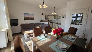 a living room with a dining room table with flowers on it at Herrenhaus Darbein in Dargun +8 photos