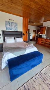 a large bed with a blue platform in a room at Rosies on Robin - Pool, Braai & Mountain Views in Rustenburg +16 photos