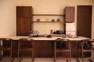 a kitchen with a counter with chairs and a sink at Paraiso Rainforest and Beach Hotel in Omoa