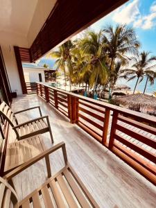 a balcony with two chairs and a view of the beach at Paraiso Rainforest and Beach Hotel in Omoa