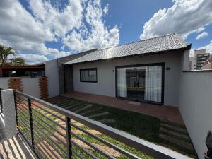 a house with a deck in front of it at Casa Nova & Aconchegante in São Bento do Sul