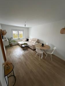a living room with a couch and a table at S&G Home Stilvolles 2-Zimmer-Apartment in zentraler Lage, Komfort & Entspannung garantiert! in Ditzingen +5 photos