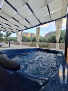 a hot tub in a patio with a view of mountains at Grand Relax Suites in Diakopto