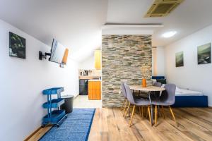 a room with a table and chairs and a brick wall at The LOFT Apartments Ljubljana in Ljubljana
