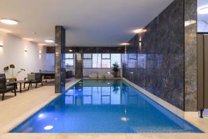 a swimming pool in a house with a tile wall at Villa Alba in Majdal Shams