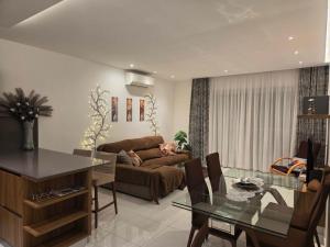 a living room with a couch and a glass table at Eivissa Apartment in Marsaskala