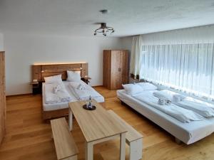 a room with two beds and a table in it at Bayerischer Wald, FVI Hotel und Restaurant in Neukirchen