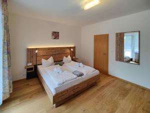 a bedroom with a large bed with a wooden headboard at Bayerischer Wald, FVI Hotel und Restaurant in Neukirchen
