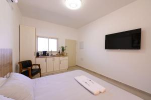 a bedroom with a bed and a flat screen tv at Villa Alba in Majdal Shams
