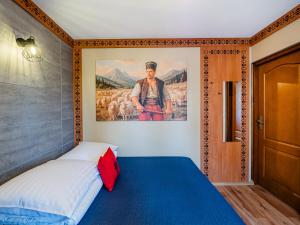 a bedroom with a bed with a painting on the wall at WERONIKA Murzasichle - podgrzewany basen zewnętrzny śniadanie i jacuzzi w cenie in Murzasichle +267 photos