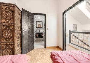 a bedroom with a large wooden door with a fireplace at 16 Riads in Marrakesh +18 photos