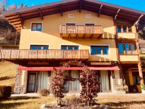 ein großes Gebäude mit einem Balkon auf dem Dach in der Unterkunft primiero-suite 45mq in Transacqua