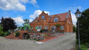 a large brick house with a street light in front of it at Herrenhaus Darbein in Dargun