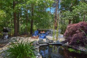 a backyard with a pond and a grill and trees at 5 Min to Beach Yard w Fire Pit in Wellfleet