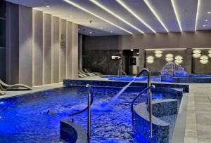 a pool with blue water in a hotel lobby at Crystal Baltic 222 in Dziwnówek