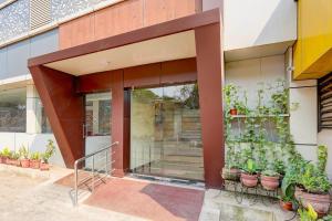 an entrance to a building with potted plants at Hotel Mini Escape Perungalathur in Chennai