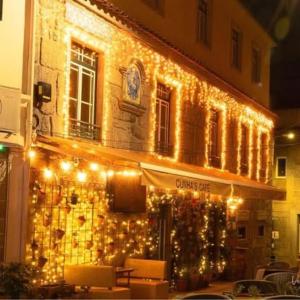 a building with christmas lights on the side of it at Pensão S José-CUNHA'S in Vila Nova de Tazem