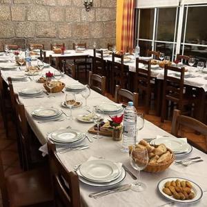 a long table with plates of food on it at Pensão S José-CUNHA'S in Vila Nova de Tazem