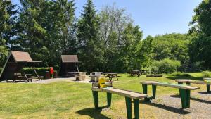 a group of picnic tables and benches in a park at Chalet Tournesol Durbuy in Durbuy +79 photos