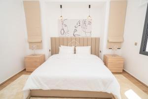 a bedroom with a large white bed and two night stands at Luxury Villa with Private Pool STR1 in Tangier +54 photos