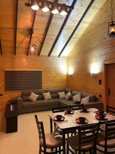 a living room with a couch and a table and chairs at شاليه غصن in Ajloun