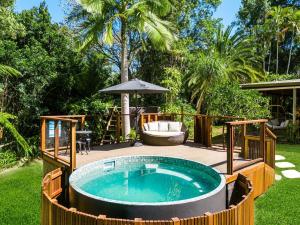 a hot tub in a backyard with an umbrella at Figtree Creek Retreat in The Pocket