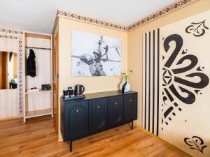 a room with a black cabinet and a painting on the wall at WERONIKA Murzasichle - podgrzewany basen zewnętrzny śniadanie i jacuzzi w cenie in Murzasichle
