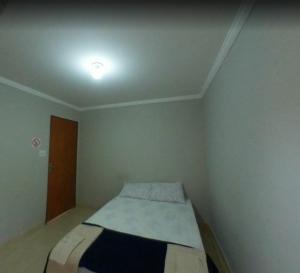 a small bedroom with a bed in a room at Cedro Assis hotel in Assis