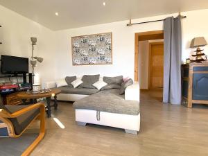 a living room with a couch and a tv at Charisma - 2 chambres Proche hypercentre in Pontarlier