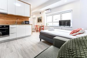 a bedroom with a large bed and a kitchen at The LOFT Apartments Ljubljana in Ljubljana +45 photos