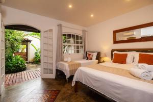 a bedroom with two beds and an open door at Boutique Hotel Carpe Diem in Paraty +151 photos