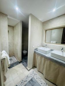a bathroom with two sinks and a toilet at Riad Blue Berry & SPA in Marrakesh