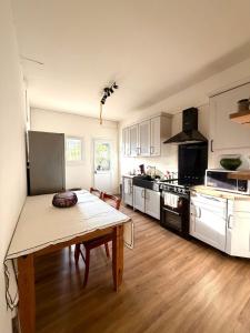 a kitchen with a wooden table and a kitchen with white cabinets at Villa San Michele 3 chambres in Linguizzetta +9 photos
