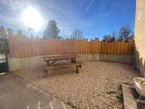 a wooden picnic table in front of a wooden fence at Charisma - 2 chambres Proche hypercentre in Pontarlier