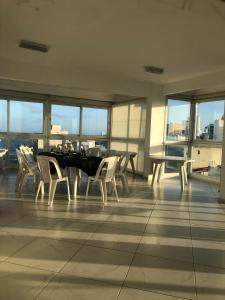 a dining room with a table and chairs and windows at Una perla a metros del mar in Mar del Plata