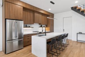 a kitchen with a stainless steel refrigerator and wooden cabinets at Modern Luxury at Copper View Moab in Moab
