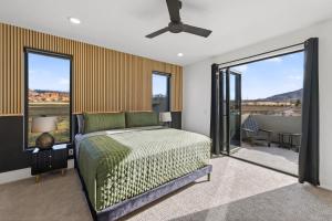 a bedroom with a bed and sliding glass doors at Modern Luxury at Copper View Moab in Moab
