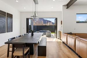 a dining room with a table and a couch at New Modern Luxury at Copper View Moab in Moab